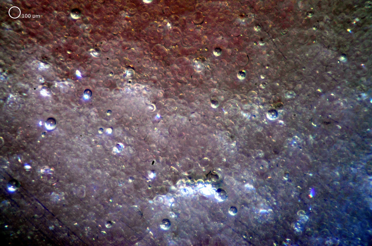 Liquid-liquid dispersion of organic-in-aqueous (i.e., "oil-in-water") from in-situ mixing in an annular centrifugal contactor. The red color comes from Nile Red fluorescence dye in the organic (dispersed) phase. Entrained air bubbles are also visible. Nikon D7000 camera was used with Infinity K1 CentriMax (with NTX 2X tube and MX-6 objective) and a SPOT 500ns Flash from Prism Science Works. Photo courtesy Kent E. Wardle, Argonne National Laboratory.